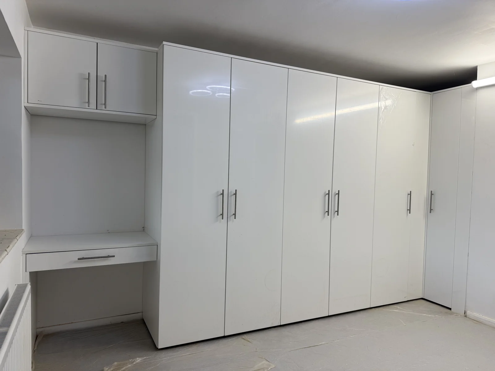 White wardrobes and a dressing area installed in a bedroom