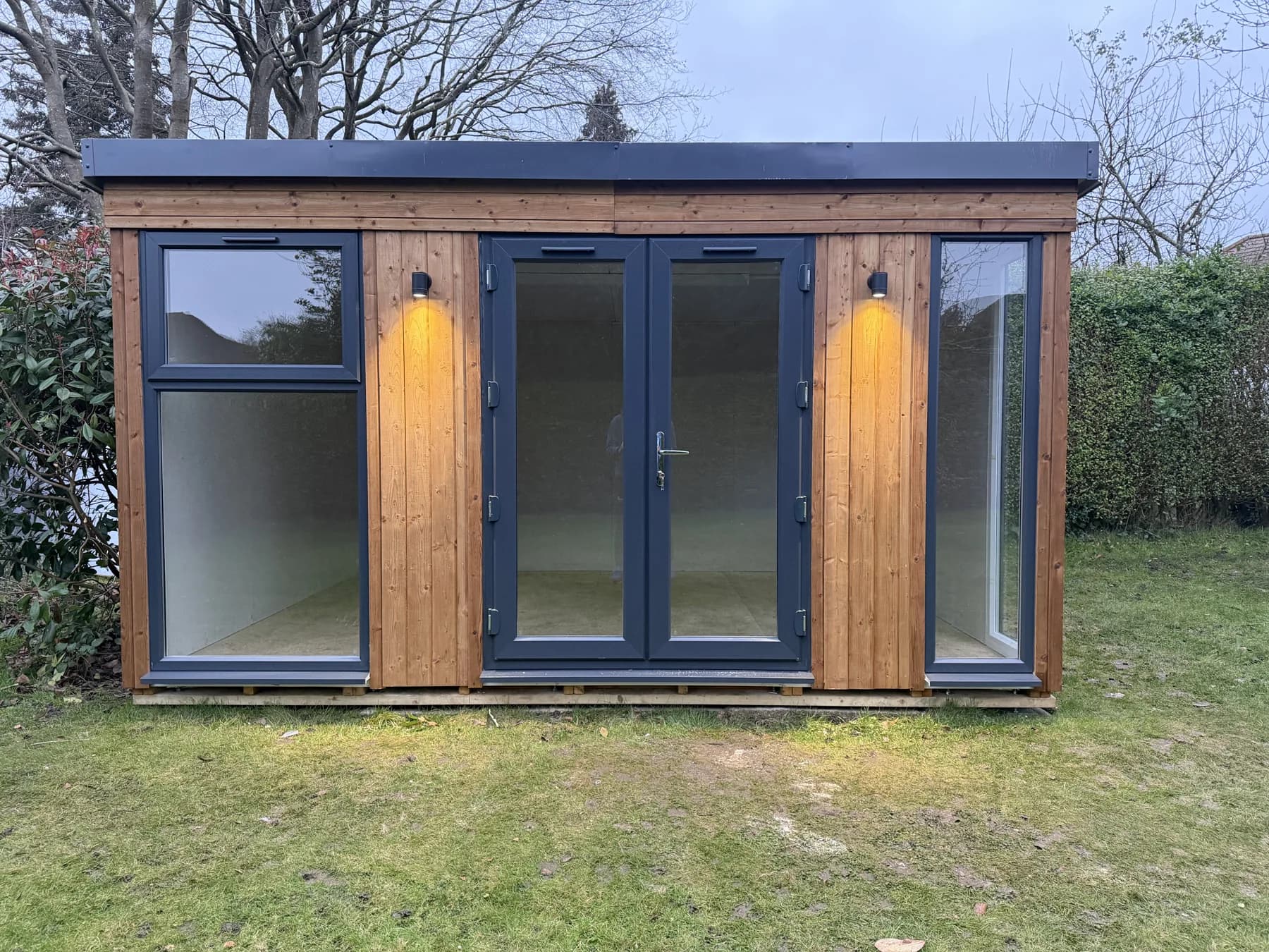 The timber-clad exterior and glazed entrance in daylight.