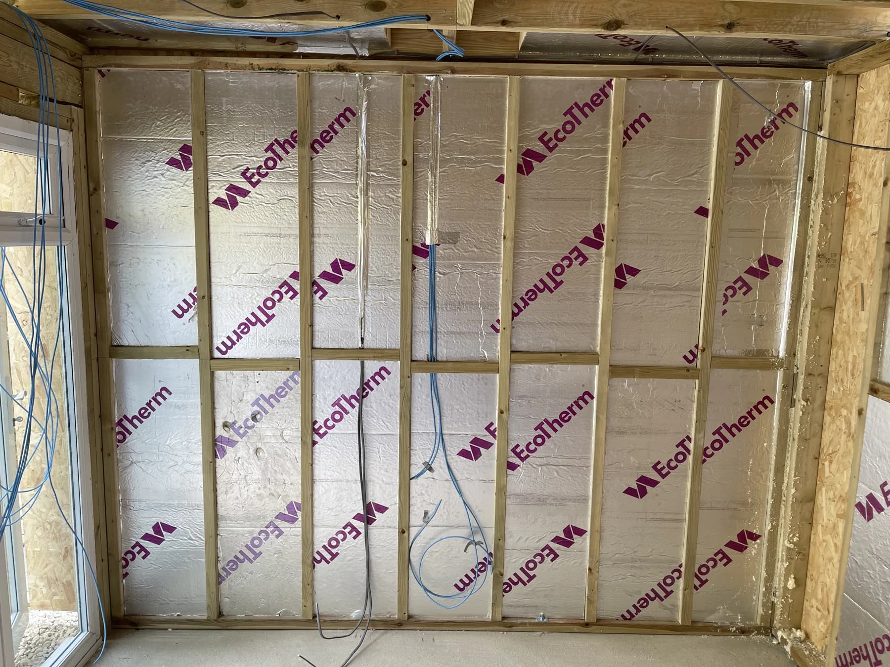 During construction — insulation fitted between the timber framing.
