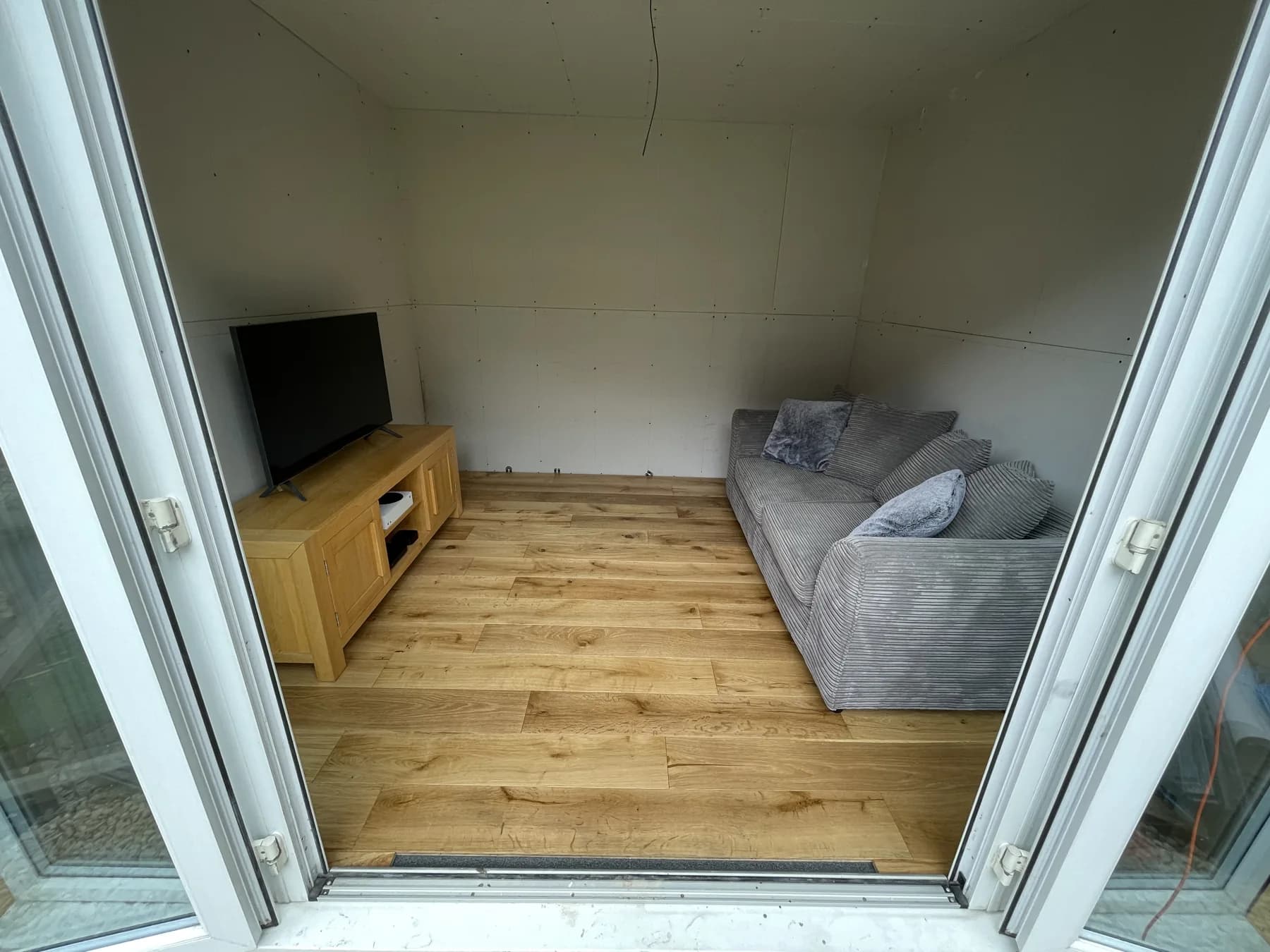 The sofa and TV in place, with some interior finishing work still to complete.
