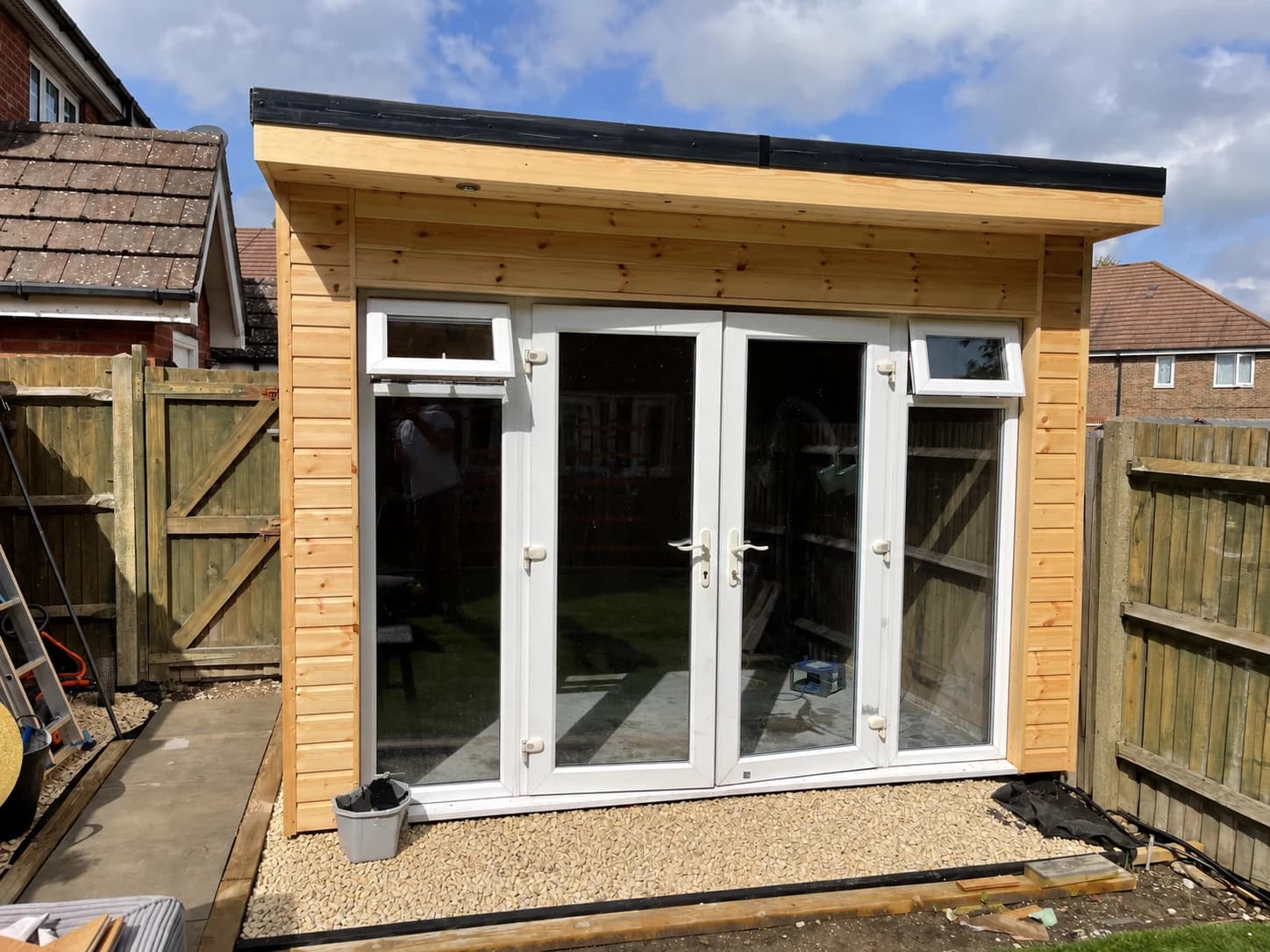 Timber-clad garden room in Netherne on the Hill with glazed doors, pictured during the final stages of work