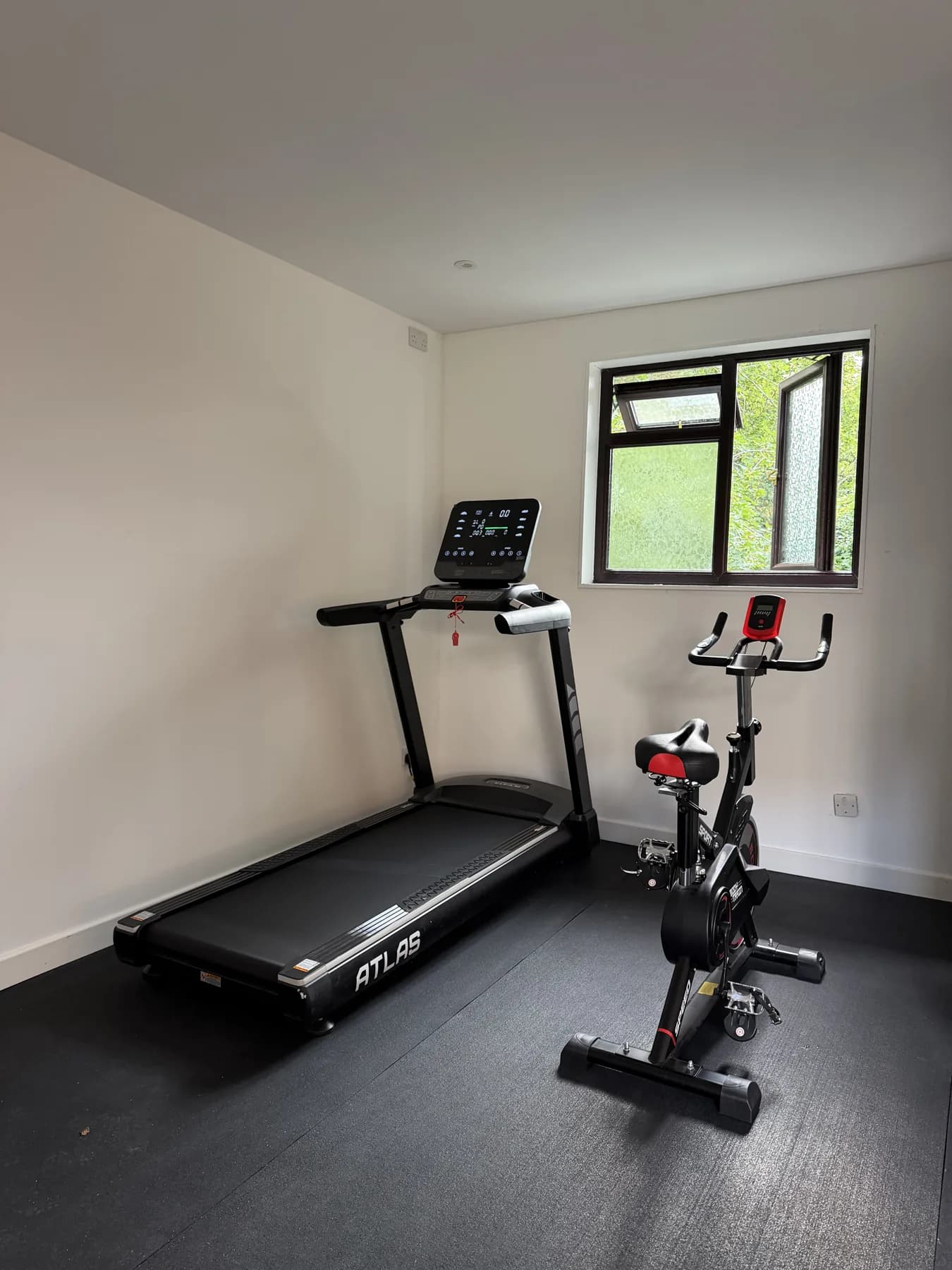 The treadmill and exercise bike in place beside the window.