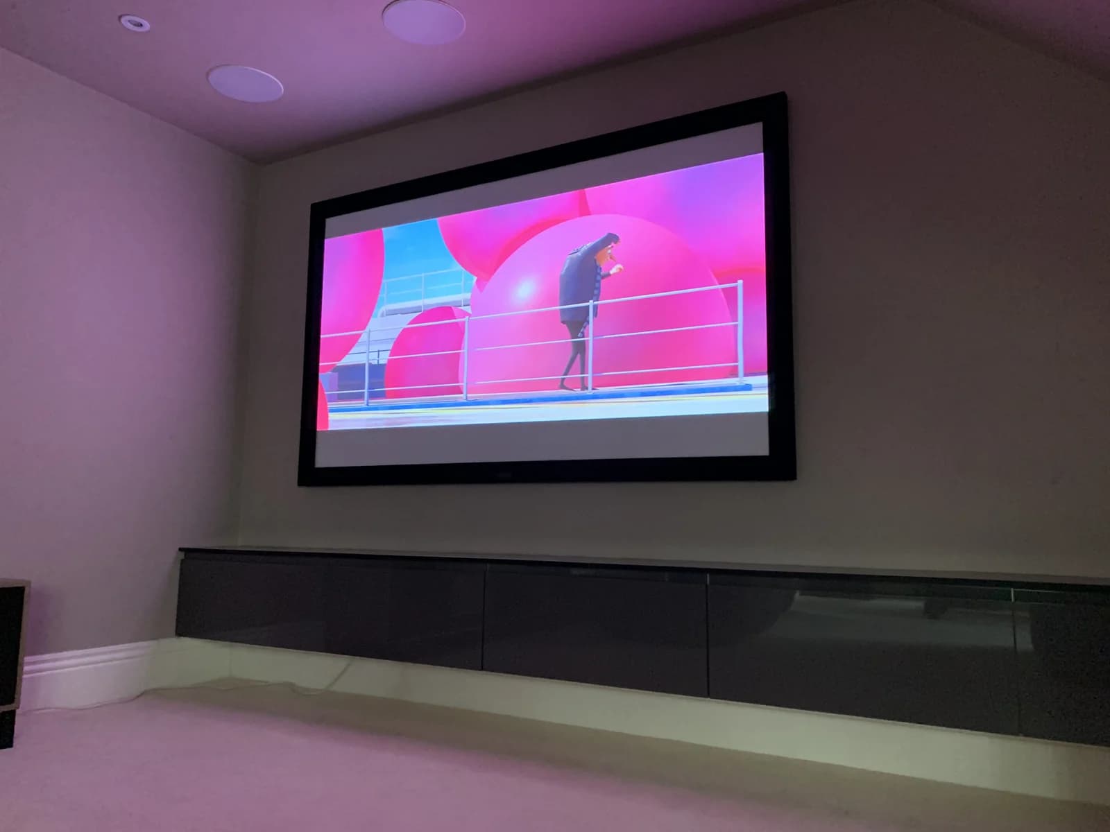 Home cinema projector screen with ceiling speakers and fitted storage