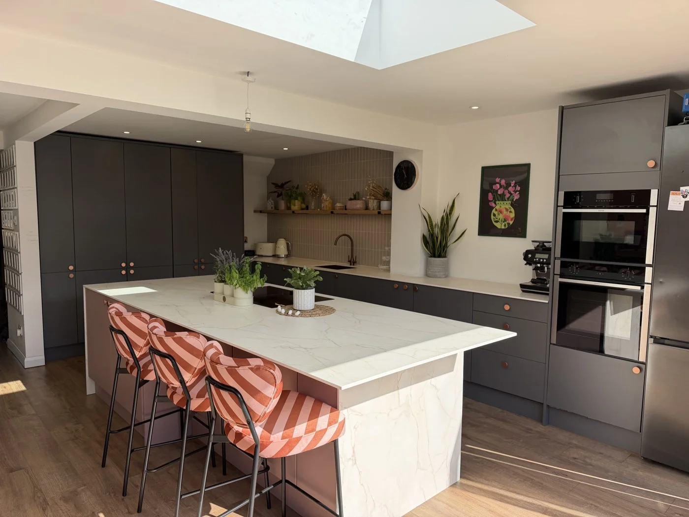 Phase two — kitchen island and dark cabinetry beneath the rooflight.