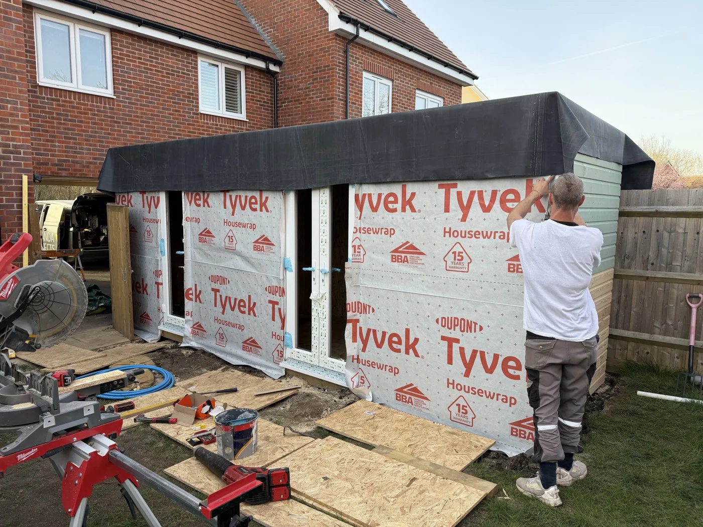 During construction — doors, exterior wrap and cladding installation.
