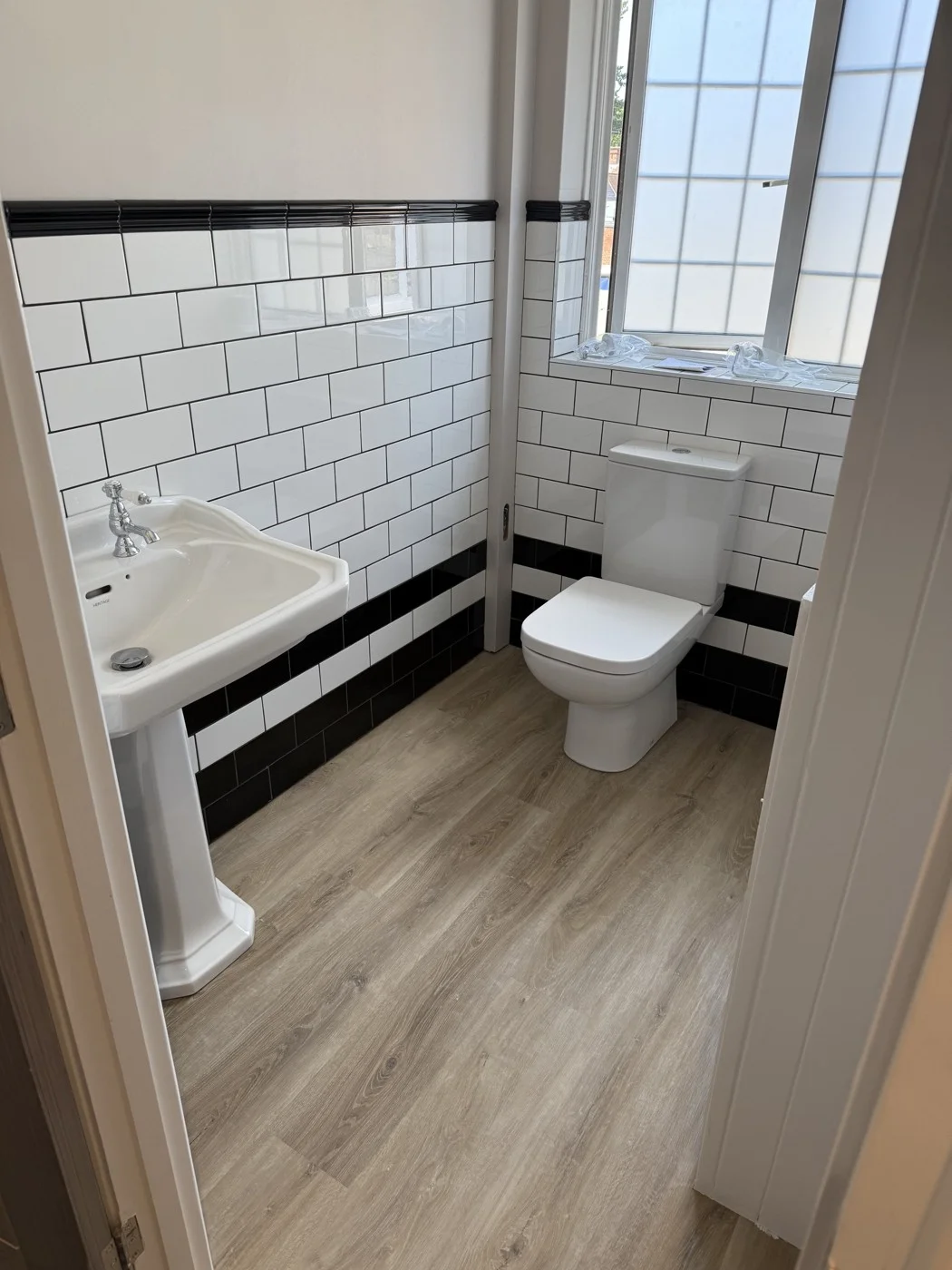The relocated toilet with tiled walls and new flooring.